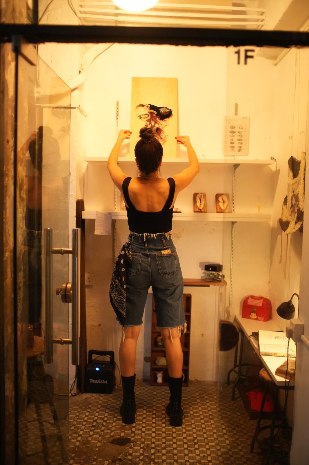 An artist standing inside a warmly lit studio space.